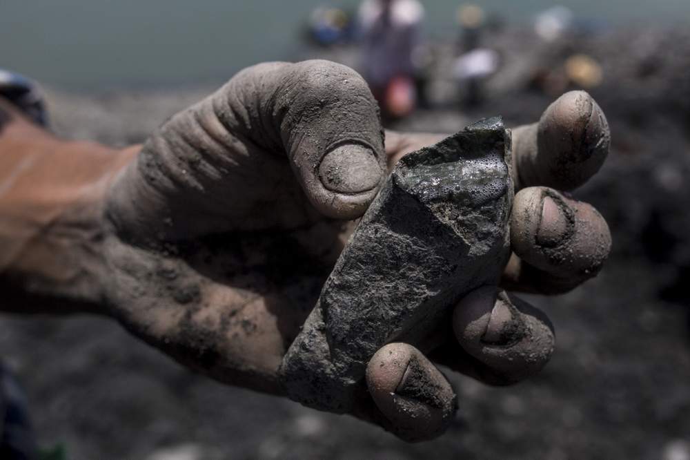 <em>A small-scale jade miner clutches a raw jade stone that he found searching on a company waste pile, Hpakant, Myanmar.</em> <br /><em>Credit: Minzayar</em>